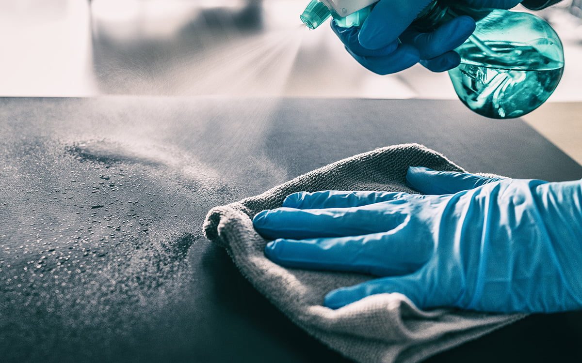 Close-up van een oppervlak dat met reiniger en microvezeldoek wordt schoongemaakt